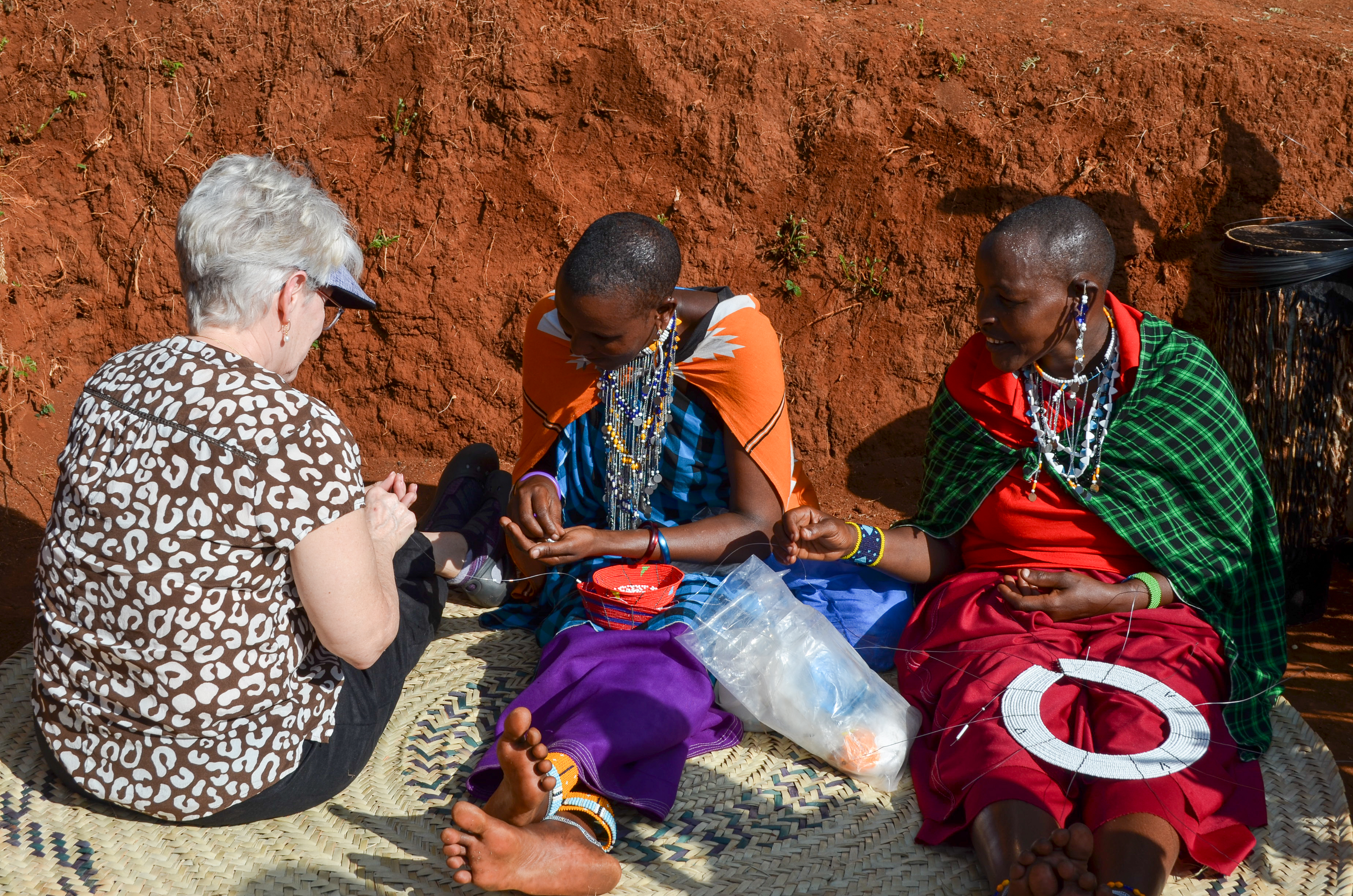 DSC_0395 MCC visitor sitting with two maasai women during a beadwork workshop